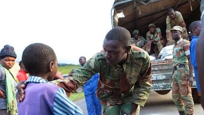 A soldier attends to a child while distributing food supplies in Chimanimani, about 600km southeast of Harare, Zimbabwe. AP Photo