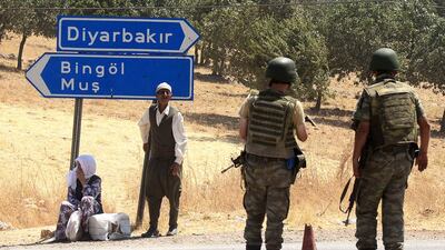 Turkish solders wait at a check point in Diyarbakir on July 26, 2015 following the death of two Turkish soldiers. A car bomb attack killed two Turkish soldiers in the Kurdish-dominated southeast of the country, after separatist rebels warned they would no longer observe a truce after Ankara's air strikes on their positions in Iraq, officials said on July 26. Turkey has launched a two-pronged "anti-terror" cross-border offensive against Islamic State (IS) jihadists and Kurdistan Workers Party (PKK) militants after a wave of violence in the country, pounding their positions with air strikes and artillery. But the expansion of the campaign to include not just IS targets in Syria but PKK rebels in neighbouring northern Iraq bitterly opposed to the jihadists has put in jeopardy a truce with the Kurdish militants that has largely held since 2013. AFP PHOTO / ILYAS AKENGIN