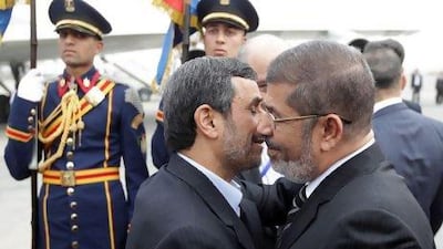 Egyptian President Mohammed Morsi (right) greets President Ahmadinejad at the Cairo airport.