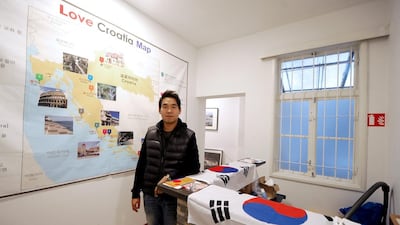 Kim Seoung-hoon poses in front of a giant map marked with Croatia’s main destinations, at the entrance of his Korean-only Love Croatia hostel in the capital Zagreb. AFP
