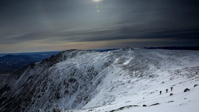 Under a midday winter solstice sun, a trio of climbers make their way up a slope on Mount Washington. AP Photo