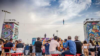 A crowd watches a tightrope walker.
