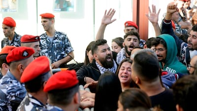 A Lebanese woman argues with security forces as she stands surrounded by protesters. AFP