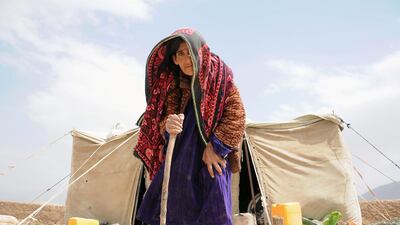 An Afghan woman stands outside her temporary shelter in an internally displaced person's (IDP) camp on the outskirts of Balkh province, Afghanistan. Sayed Mustafa / EPA