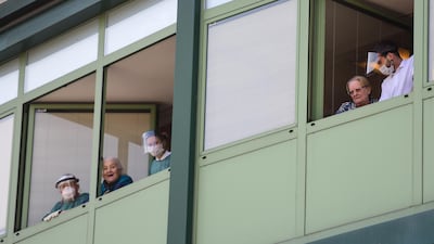 Medical personnel and hosts cheer from the windows of the Honegger nursing home where 35 people have died so far from coronavirus in Albino, Italy. AFP