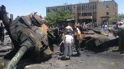Anti-Syrian regime citizens look at Syrian tank that was damaged during clashes between rebels and Syrian government forces, in Ariha in Idlib province. Rebel fighters killed at least 80 government soldiers at the weekend, according to the opposition Syrian Observatory for Human Rights.