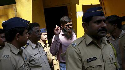 One of the twelve men, convicted of planning several blasts on crowded commuter trains in the financial capital of Mumbai in 2006, gestures as he is escorted by police to a court in Mumbai,. Danish Siddiqui / Reuters