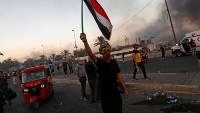 A protesters holds up the Iraqi flag during an anti-government demonstration in Baghdad on October 5, 2019. Reuters