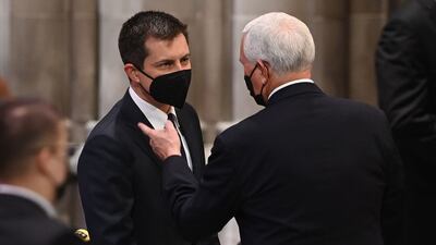 Former US vice president Mike Pence speaks with Transport Secretary Pete Buttigieg at the Washington National Cathedral. AFP