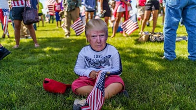 A supporter wears a mask of US President Donald Trump in Mankato, Minnesota as the president delivers remarks on jobs and the economy. AFP