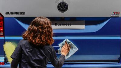 A worker polishes a Volkswagen multivan on display during Volkswagen's annual general meeting in Hanover. John MacDougal/AFP