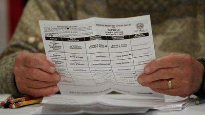 Town moderator Tom Tillotson holds a ballot shortly after midnight for the U.S. presidential election at the Hale House at Balsams Hotel in the hamlet of Dixville Notch, New Hampshire. Reuters