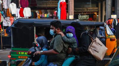 An Indian family wearing face masks as a precaution against the coronavirus rides on a scooter through a street in Hyderabad, India. India has more than 9 million cases of coronavirus, second behind the United States. AP