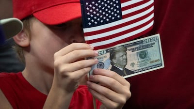 A child holds a '2020' US dollar bill with a picture of US President Donald Trump during Trump's 2020 re-election bid announcement in Orlando, Florida, USA. EPA