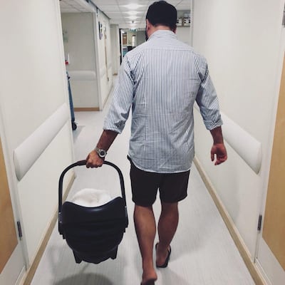 Katie Watson Grand's husband, Lewis Grant, who was able to stay and work from their room at the hospital thanks to a full-size bed and office area, carries Rafferty home. Courtesy Katie Watson Grant