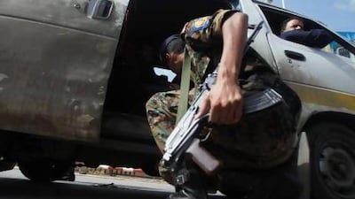 A police trooper checks a van at the entrance of Sanaa International Airport after intelligence agents uncovered a terror threat by Al Qaeda on the Arabian Peninsula.