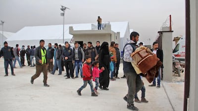 Syrian rebel fighters and their families arrive at a temporary shelter in Idlib province on November 29, 2016, following their evacuation from rebel-held territory on the outskirts of Damascus. Omar Haj Kadour/AFP