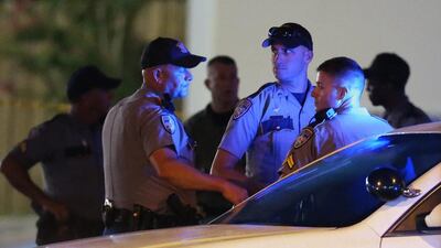Law enforcement officials work the scene near where multiple Baton Rouge police officers were killed on Sunday, in Baton Rouge. Curtis Compton / Atlanta-Journal Constitution via AP