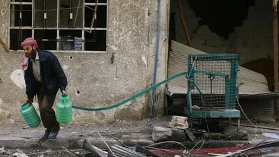 A man carries water cannisters in the besieged town of Douma, Eastern Ghouta, Damascus on February 25, 2018. Bassam Khabieh / Reuters