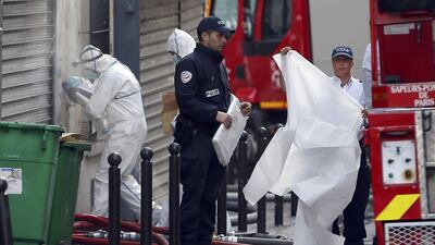 French investigators at work in front of the apartment building in which a fire broke-out overnight in central Paris. Charles Platlau / Reuters