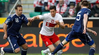 Robert Lewandowski fights for the ball against Andorra's Manel Josep Ayala and Emili Garcia