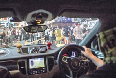 Chen makes his way through the crowds as he gives a volunteer medic a ride away from the protests safely to his home. Rick Findler for The National