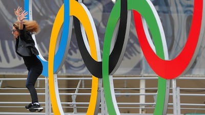 A woman jumps in front of the Olympic rings. Vadim Ghirda / AP Photo