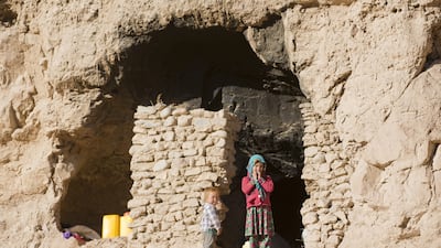 Shepha Qah, 8, and her brother stand by the entrance of their cave in Bamiyan, Afghanistan. Their family and about 240 others living in caves are to be moved away as part of a government plan to turn the area into a tourist site. Massoud Hossaini / AP Photo