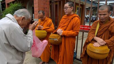 A Thai man prays to Buddhist monks. AFP