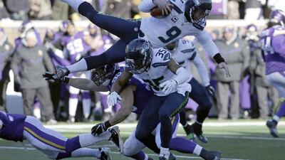Seattle Seahawks punter Jon Ryan (9) jumps over Minnesota Vikings linebacker Casey Matthews (59) as he runs the ball during the first half of an NFL wild-card football game against the Minnesota Vikings, Sunday, Jan. 10, 2016, in Minneapolis. (AP Photo/Nam Y. Huh)