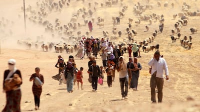 Displaced Yazidis flee ISIS by walking towards the Syrian border, near Sinjar mountain, Iraq, August 10, 2014. Reuters