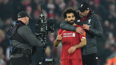 A cameraman films Liverpool's German manager Jurgen Klopp embracing Mohamed Salah. AFP