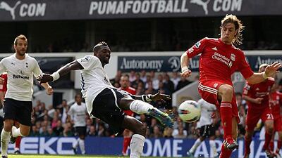 Emmanuel Adebayor shoots and scores Tottenham's fourth goal in their 4-0 victory against nine-man Liverpool at White Hart Lane. Clive Rose / Getty Images