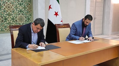 Syria's leader Ahmed Al Shara, right, and SDF commander-in-chief Mazlum Abdi signing an agreement to integrate the SDF into state institutions, in the Damascus on March 10. AFP