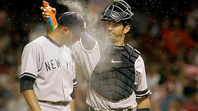 The Yankees’ Jorge Posada, right, applies bug spray to Mariano Rivera during a game. New rules stipulate that once a batter steps into the box, he must stay unless a stinging insect lands on him.