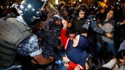 Protesters lie on a road, as they scream and hold each others while riot police try to remove them and open the road, in Beirut. AP Photo