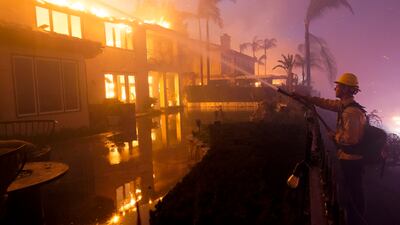 At least 20 homes were destroyed as the wildfire spread through southern California overnight. AP