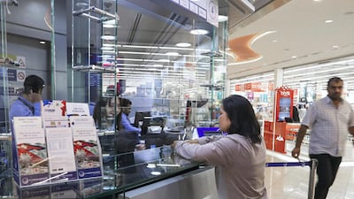 A Filipina sends money back home from a remittance centre in Abu Dhabi, as the exchange rate sat as its most favourable in more than 10 years. Victor Besa / The National