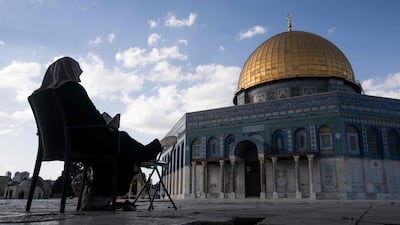 A Muslim woman reads the Quran at Al Aqsa Mosque compound, in the Old City of Jerusalem. AFP