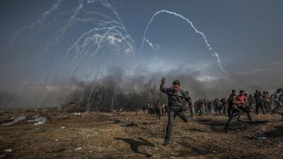 Palestinians protesters run for cover from tear-gas fired by Israeli soldiers during clashes after Friday protests near the border with Israel. EPA/MOHAMMED SABER