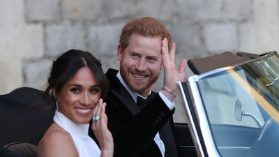 Meghan and Prince Harry wave as they leave Windsor Castle after their wedding to attend an evening reception at Frogmore House, in May 2018. Getty Images