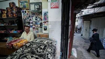Ahmad Rizeq reads the newspaper while waiting for the rare customer in his Old City shop.