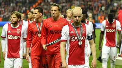 Ajax players leave the field after collecting their runner-up medals. Peter Powell / EPA