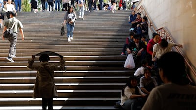 Chinese tourists rest at the underpass of the Tiananmen Square in Beijing. EPA