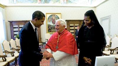 Pope Benedict XVI and Barack Obama, the US president, exchange gifts as the first lady, Michelle Obama, watches at the Vatican.
