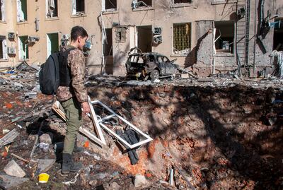 A man assesses a crater in the road after heavy Russian shelling in Kharkiv. EPA