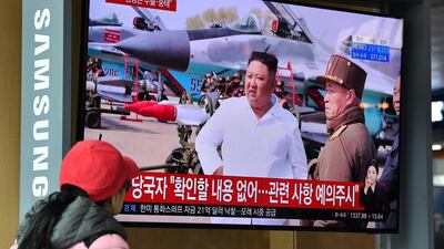 A woman watches a television news broadcast showing file footage of North Korean leader Kim Jong Un, at a railway station in Seoul on April 21, 2020. AFP