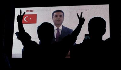 Supporters of Turkey's main pro-Kurdish Peoples' Democratic Party (HDP) watch the jailed former leader and presidential candidate Selahattin Demirtas as his first television appearance in over a year and a half is seen live on a huge screen during campaign event in Istanbul, Turkey, June 17, 2018. Huseyin Aldemir / Reuters File Photo