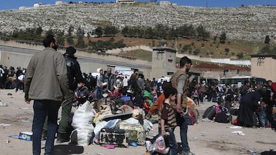 Syrian civilians and rebel fighters evacuated from Eastern Ghouta arrive in the village of Qalaat al-Madiq, some 45 kilometres northwest of the central city of Hama, on March 26, 2018, as evacuations from Eastern Ghouta continued following a deal that was announced earlier in the week. Abdulmonam Eassa / AFP