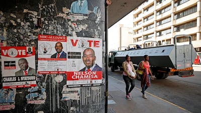 Women walk past police in vehicles parked outside the headquarters of the opposition Movement for Democratic Change (MDC) a day after post-election clashes between security forces and opposition protesters in Harare, Zimbabwe, on August 2, 2018. Reuters